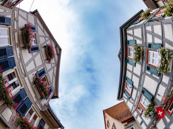 Fischaugenperspektive von Fachwerkh&auml;usern in Besigheim. Die Geb&auml;ude haben blaue Fensterl&auml;den und Blumenk&auml;sten, die den traditionellen Charme betonen., &copy; Stadt Besigheim