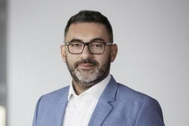 Ein Mann mit Brille und Bart trägt einen blauen Anzug und ein weißes Hemd. Er steht vor einem grauen Hintergrund., © Stadt Esslingen am Neckar