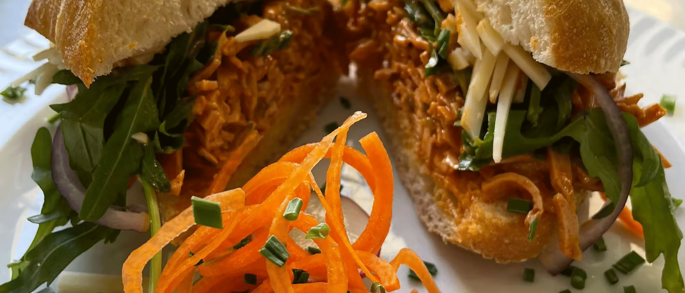 Ein belegtes Brötchen mit Rucola, Karottenstreifen und Käse, garniert mit Schnittlauch. Im Vordergrund sind Karottenstreifen zu sehen., © Schönbuch Waldbiergarten am Wasserturm Ein belegtes Brötchen mit Rucola, Karottenstreifen und Käse, garniert mit Schnittlauch. Im Vordergrund sind Karottenstreifen zu sehen., © Schönbuch Waldbiergarten am Wasserturm