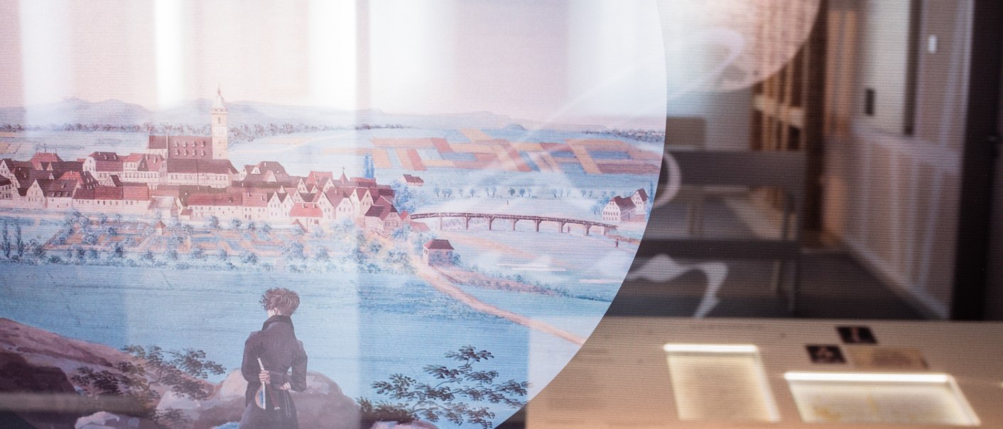 Ein Gemälde in einer Ausstellung zeigt eine historische Stadtansicht mit einer Person im Vordergrund. Im Hintergrund sind Ausstellungstafeln sichtbar., © dieargelola, Stuttgart