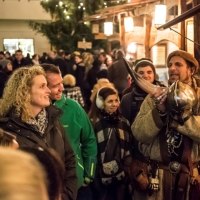 Ein Mann in mittelalterlicher Kleidung zeigt ein Horn auf einem belebten Mittelaltermarkt. Besucher schauen interessiert zu., © Esslinger Stadtmarketing &amp; Tourismus GmbH
