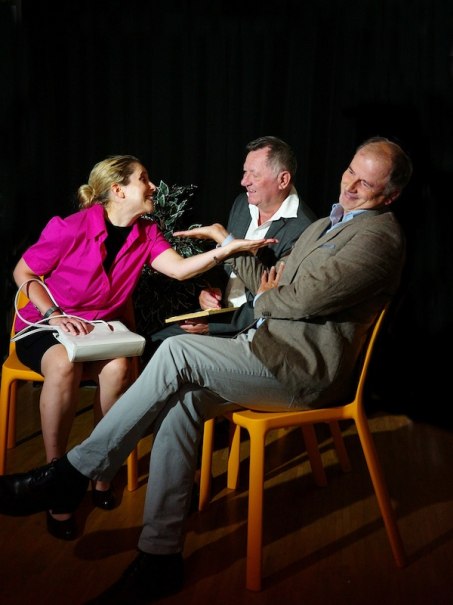 Drei Personen sitzen auf orangefarbenen Stühlen und führen eine lebhafte Diskussion. Eine Frau in pinker Bluse gestikuliert, während zwei Männer lächeln., © Stadtverwaltung Marbach
