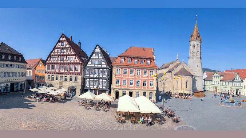 Historische Gebäude und Johanniskirche an einem sonnigen Marktplatz mit Cafés und Brunnen., © Foto Thomas Zehnder Hostrup Fotografie Historische Gebäude und Johanniskirche an einem sonnigen Marktplatz mit Cafés und Brunnen., © Foto Thomas Zehnder Hostrup Fotografie