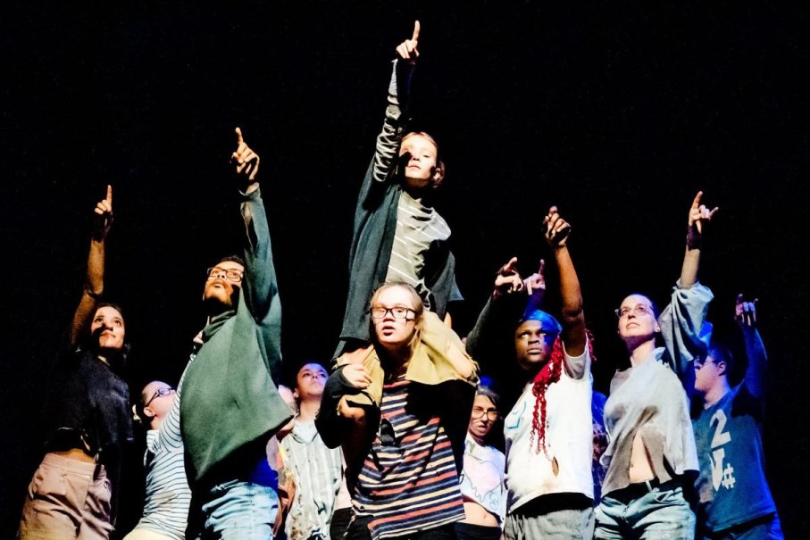 Eine Gruppe von Menschen auf einer Bühne, die energisch nach oben zeigt. Sie tragen lässige Kleidung und wirken entschlossen., © Heiko Pothoff, Eduardo P. Bruges, Reiner Pfisterer