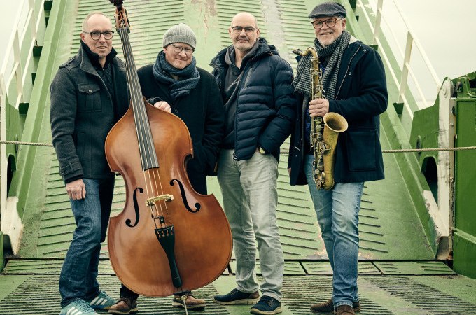 Vier M&auml;nner posieren auf einer gr&uuml;nen Rampe. Einer h&auml;lt einen Kontrabass, ein anderer ein Saxophon. Sie tragen Winterkleidung und l&auml;cheln in die Kamera., &copy; Stadt Waldenbuch