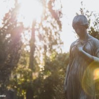 Eine melancholische Statue einer Frau auf einem Friedhof, beleuchtet von der untergehenden Sonne, die durch die B&auml;ume scheint., &copy; Eigenbetrieb Tourismus und Citymanagement Schorndorf