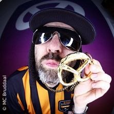 Person mit Sonnenbrille und Mütze hält eine Brezel vor einem lila Hintergrund. Trägt ein gestreiftes Trikot., © links im Bild Person mit Sonnenbrille und Mütze hält eine Brezel vor einem lila Hintergrund. Trägt ein gestreiftes Trikot., © links im Bild