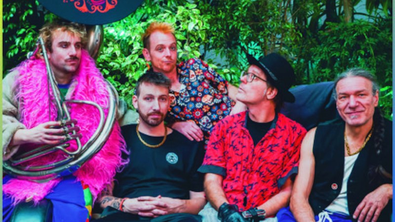 Fünf Männer in bunter Kleidung sitzen auf einem Sofa, umgeben von Pflanzen. Oben links das Logo 'Malaka Hostel'. Text: 'Brucca Beat Tour'., © Kulturhaus Schwanen Fünf Männer in bunter Kleidung sitzen auf einem Sofa, umgeben von Pflanzen. Oben links das Logo 'Malaka Hostel'. Text: 'Brucca Beat Tour'., © Kulturhaus Schwanen