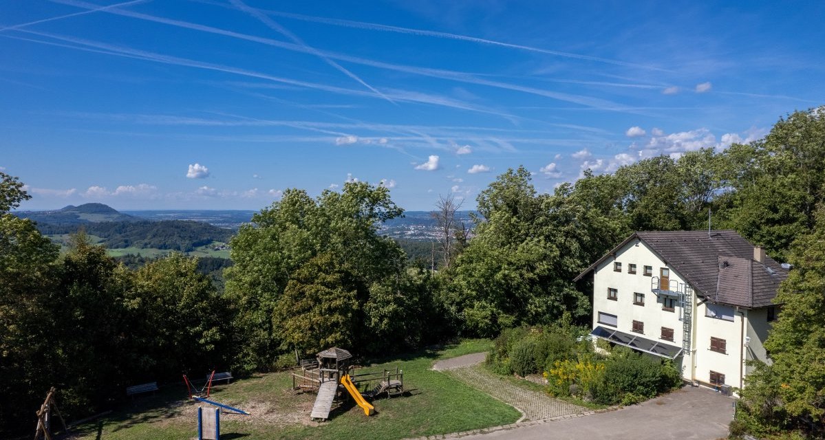 Haus am Waldrand mit Spielplatz, weitem Blick über die Landschaft. Blauer Himmel mit Kondensstreifen., © Foto Thomas Zehnder Haus am Waldrand mit Spielplatz, weitem Blick über die Landschaft. Blauer Himmel mit Kondensstreifen., © Foto Thomas Zehnder