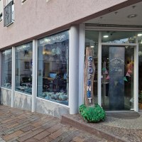 Au&szlig;enansicht eines Keramikstudios mit gro&szlig;en Fenstern. Ein Schild mit 'Ge&ouml;ffnet' steht vor der T&uuml;r. Innen sind Keramiken und Dekorationen sichtbar., &copy; StadtN&uuml;rtingen