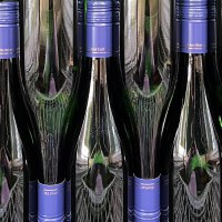Mehrere Weinflaschen mit blauen Verschlüssen stehen dicht nebeneinander. Die Flaschen sind dunkel und reflektieren das Licht., © Weinhof Zaiß Mehrere Weinflaschen mit blauen Verschlüssen stehen dicht nebeneinander. Die Flaschen sind dunkel und reflektieren das Licht., © Weinhof Zaiß
