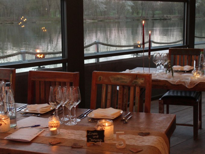 Ein romantisch gedeckter Tisch in einem Restaurant mit Kerzenlicht und Blick auf einen See. Der Tisch ist für ein Blind-Date Dinner vorbereitet., © Cool-Tours StattReisen