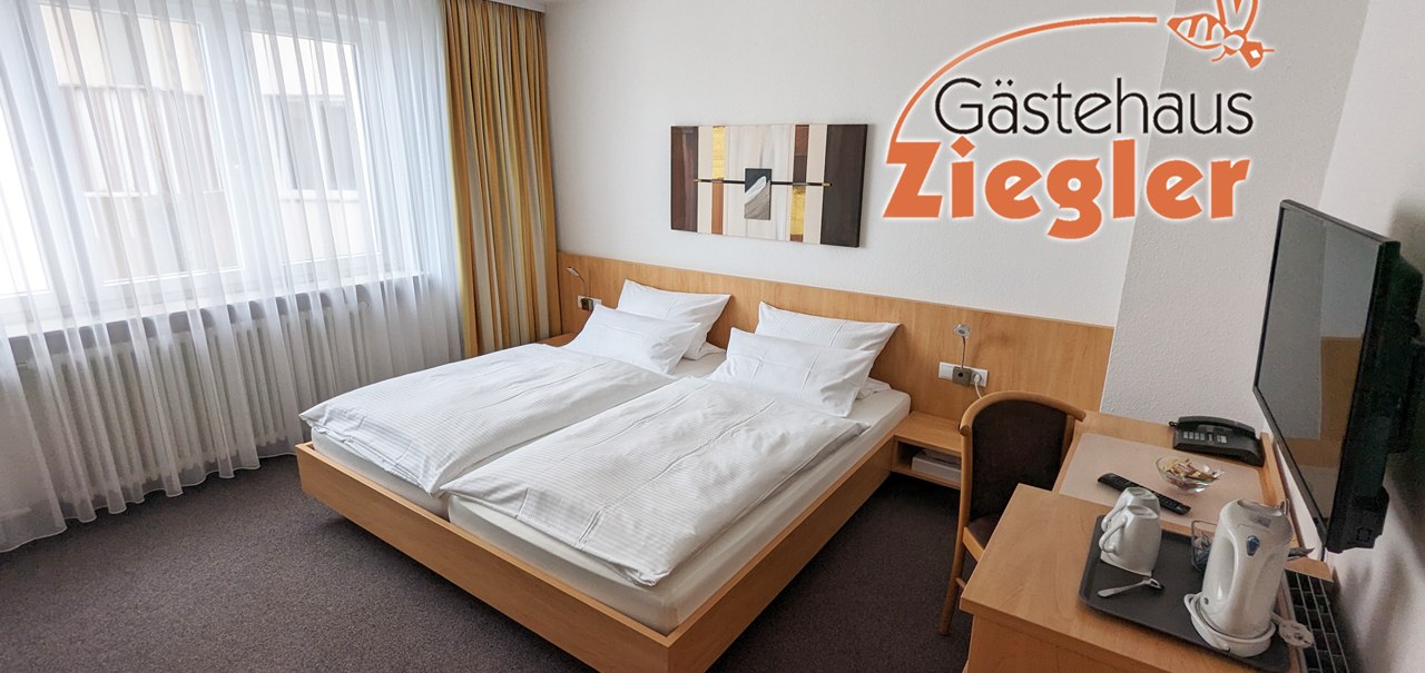 Helles Hotelzimmer mit Doppelbett, Schreibtisch, Fernseher und Wasserkocher im Gästehaus Ziegler. Moderne Dekoration und große Fenster mit Vorhängen., © Gästehaus Ziegler