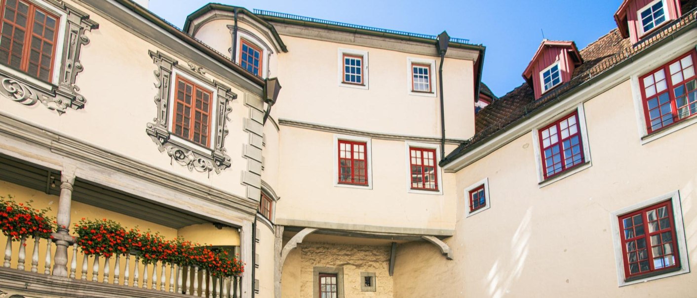 Innenhof des Alten Schlosses in Gaildorf. Historische Architektur mit verzierten Fenstern und einem Balkon mit roten Blumen., © Stuttgart-Marketing GmbH, Sarah Schmid