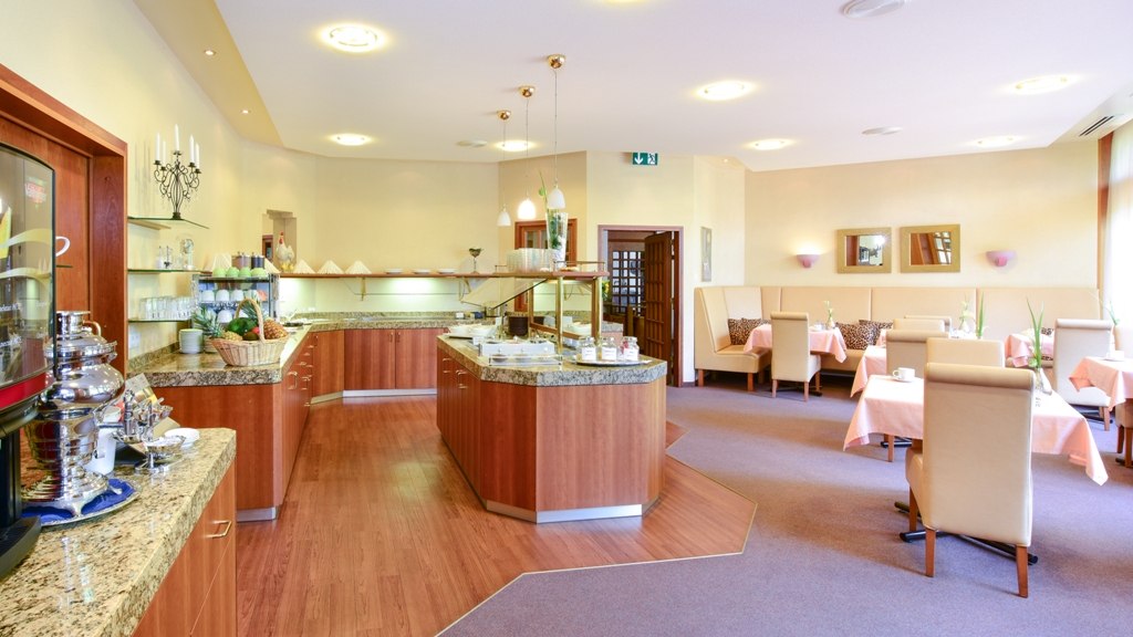 Eleganter Frühstücksraum mit Buffet, gedeckten Tischen und bequemen Stühlen. Warme Holztöne und sanfte Beleuchtung schaffen eine einladende Atmosphäre., © Hotel Fuchsen Eleganter Frühstücksraum mit Buffet, gedeckten Tischen und bequemen Stühlen. Warme Holztöne und sanfte Beleuchtung schaffen eine einladende Atmosphäre., © Hotel Fuchsen