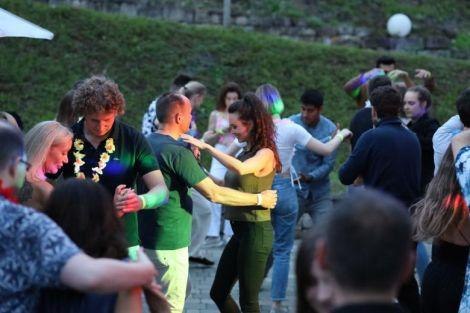 Menschen tanzen fr&ouml;hlich in einer Gruppe im Freien. Die Stimmung ist ausgelassen und die Umgebung wirkt entspannt und gesellig., &copy; Wein & Tanz. Foto: Teamwerk