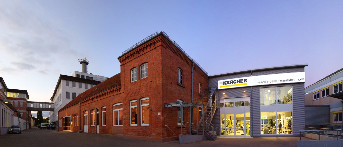 Das Kärcher Center in Winnenden zeigt eine moderne Fassade neben einem historischen Backsteingebäude bei Dämmerung., © SMG, Achim Mende Das Kärcher Center in Winnenden zeigt eine moderne Fassade neben einem historischen Backsteingebäude bei Dämmerung., © SMG, Achim Mende