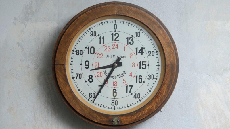 Eine alte Wanduhr mit Holzrahmen zeigt eine 24-Stunden-Anzeige. Die Ziffern sind in Schwarz und Rot auf weißem Hintergrund., © Ludwigsburg Museum Eine alte Wanduhr mit Holzrahmen zeigt eine 24-Stunden-Anzeige. Die Ziffern sind in Schwarz und Rot auf weißem Hintergrund., © Ludwigsburg Museum