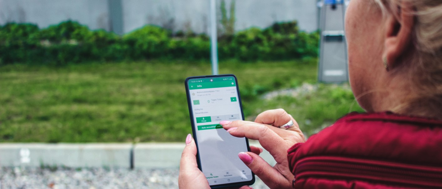 Eine Person bedient eine App auf einem Smartphone, vermutlich auf einem Wohnmobilstellplatz. Im Hintergrund sind Gras und ein Automat zu sehen., © Erlebnisregion Schwäbischer Albtrauf e.V. Eine Person bedient eine App auf einem Smartphone, vermutlich auf einem Wohnmobilstellplatz. Im Hintergrund sind Gras und ein Automat zu sehen., © Erlebnisregion Schwäbischer Albtrauf e.V.