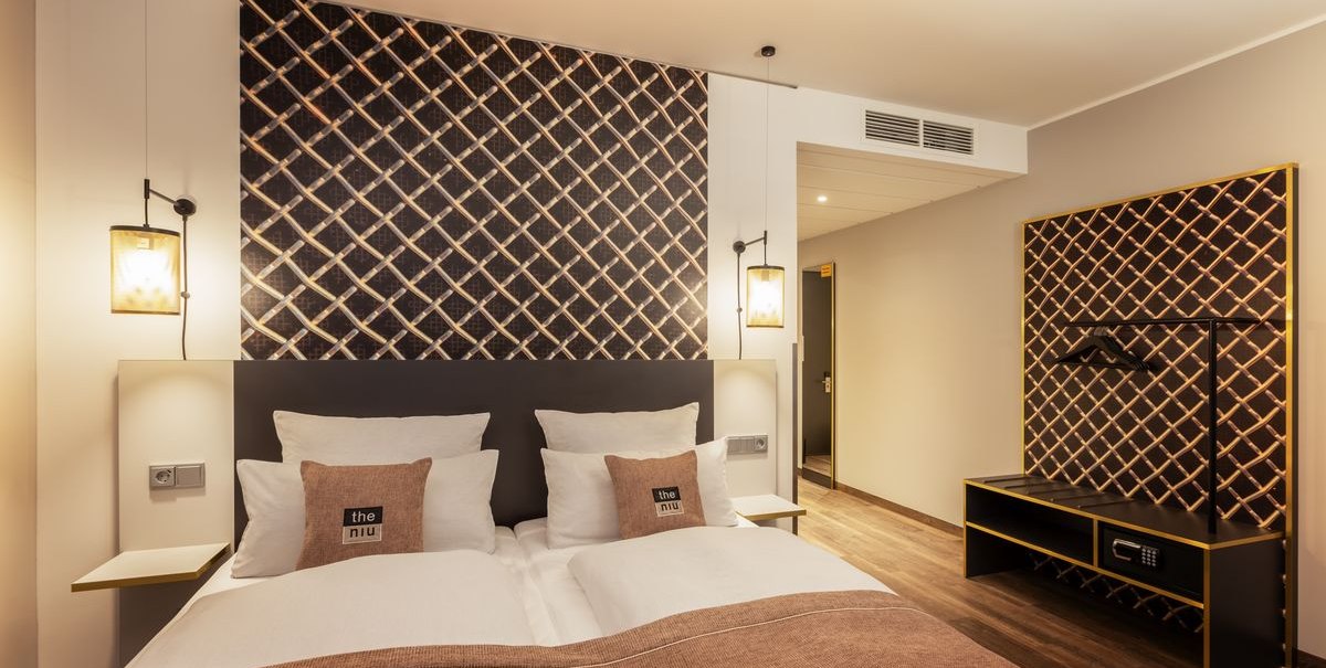 Modernes Hotelzimmer mit Doppelbett, stilvoller Wanddekoration und Holzfußboden. Dezente Beleuchtung und minimalistische Einrichtung., © Novum Hospitality Modernes Hotelzimmer mit Doppelbett, stilvoller Wanddekoration und Holzfußboden. Dezente Beleuchtung und minimalistische Einrichtung., © Novum Hospitality