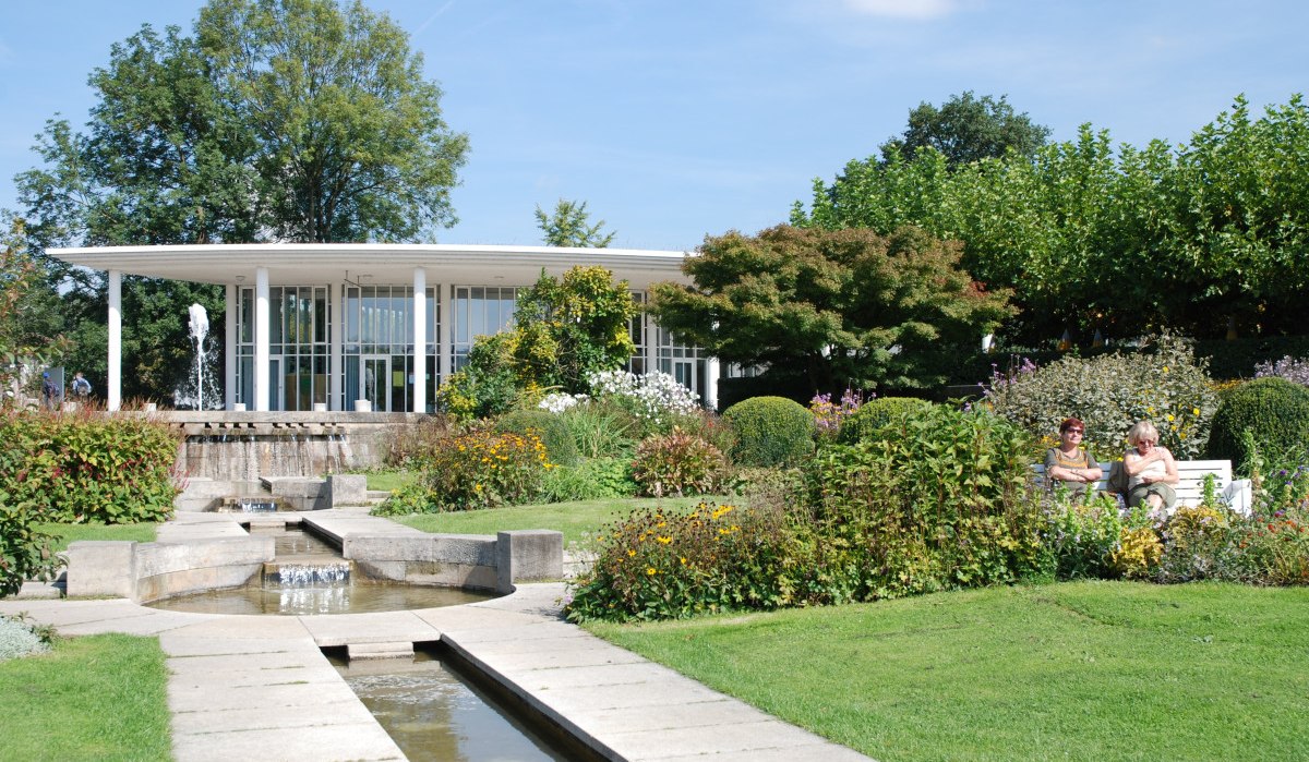 Der Enzpavillon im Bürgergarten Bietigheim-Bissingen, umgeben von blühenden Gärten und einem kleinen Brunnen. Zwei Personen sitzen auf einer Bank., © 3B-Tourismus-Team Der Enzpavillon im Bürgergarten Bietigheim-Bissingen, umgeben von blühenden Gärten und einem kleinen Brunnen. Zwei Personen sitzen auf einer Bank., © 3B-Tourismus-Team
