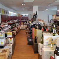 Ein Weinladen mit Regalen voller Weinflaschen und Kartons. Der Boden ist aus Holz, die Beleuchtung ist hell., &copy; Weinhaus Gallier