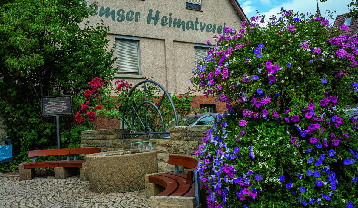 Blumenreicher Platz mit Brunnen und Bänken vor einem Gebäude des Heimatvereins in Remseck am Neckar. Blumenreicher Platz mit Brunnen und Bänken vor einem Gebäude des Heimatvereins in Remseck am Neckar.