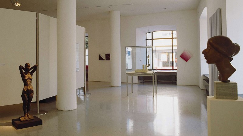 Galerie mit Skulpturen und Kunstwerken, darunter eine weibliche Figur und eine Büste. Helle Wände und große Fenster schaffen eine offene Atmosphäre., © Stuttgart-Marketing GmbH