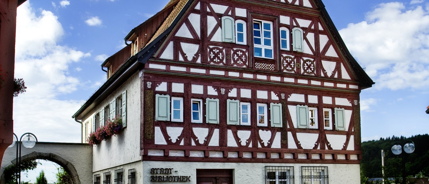 Fachwerkhaus in Plochingen mit rotem und weißem Muster, blauer Himmel und gepflasterter Platz im Vordergrund., © Thomas Pressel