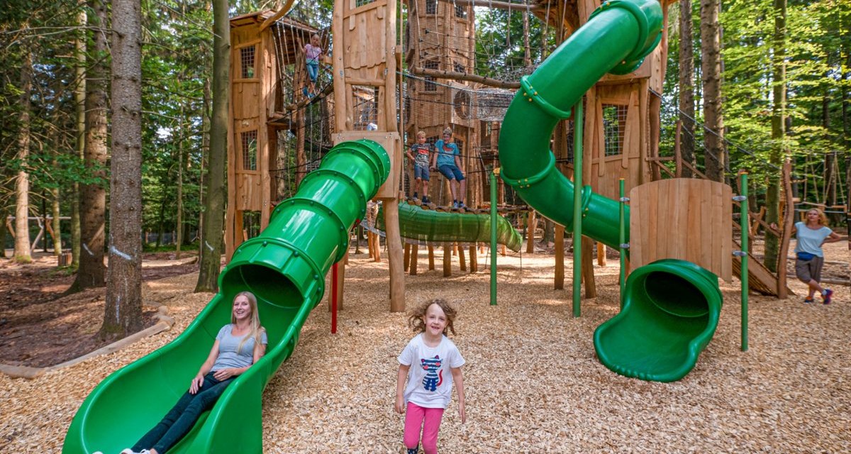 Kinder spielen auf einem Abenteuerspielplatz im Wald mit gr&uuml;nen Rutschen und Holzkletterger&uuml;sten., &copy; N&ouml;rdlicher Schwarzwald