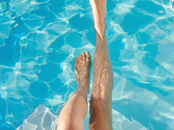 Zwei Beine tauchen in das klare, blaue Wasser eines Pools ein. Die Sonne reflektiert auf der Wasseroberfläche und erzeugt ein Spiel aus Licht und Schatten., © Stadtwerke Ludwigsburg-Kornwestheim GmbH Zwei Beine tauchen in das klare, blaue Wasser eines Pools ein. Die Sonne reflektiert auf der Wasseroberfläche und erzeugt ein Spiel aus Licht und Schatten., © Stadtwerke Ludwigsburg-Kornwestheim GmbH