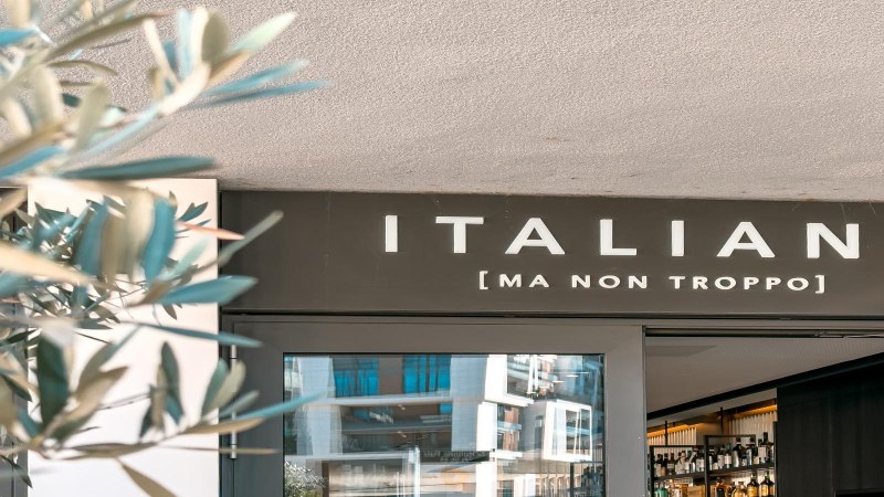 Eingang eines Restaurants mit dem Schild 'ITALIANI [MA NON TROPPO]'. Im Vordergrund sind unscharfe Pflanzen zu sehen., &copy; SMG Stuttgart Marketing GmbH - Sarah Schmid