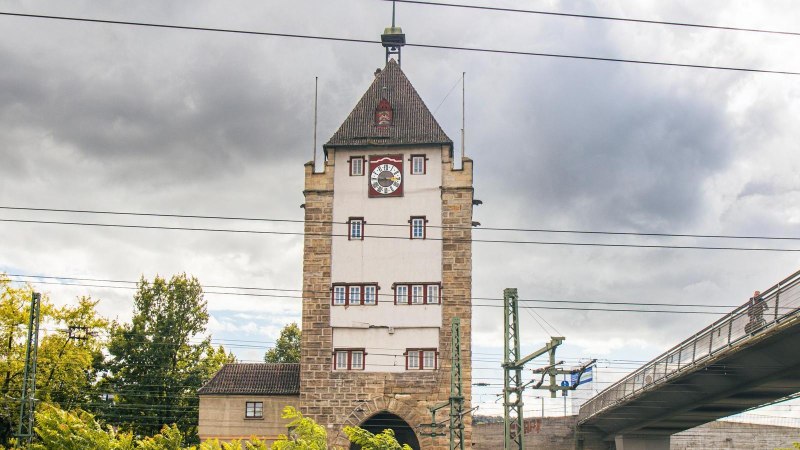 Der Pliensauturm in Esslingen steht neben einer modernen Brücke. Der Himmel ist bewölkt, und Stromleitungen verlaufen quer über das Bild., © SMG, Sarah Schmid Der Pliensauturm in Esslingen steht neben einer modernen Brücke. Der Himmel ist bewölkt, und Stromleitungen verlaufen quer über das Bild., © SMG, Sarah Schmid