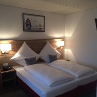 Gemütliches Doppelzimmer mit Holzkopfteil, zwei Kissen, zwei Nachttischen und einem Bild an der Wand., © Hotel Lamm Hegnach
