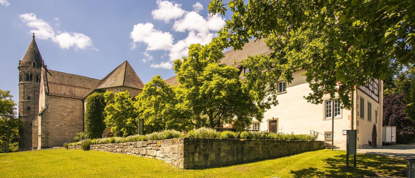 Das Kloster Lorch in einer sonnigen Landschaft mit grünen Bäumen und einem klaren blauen Himmel im Hintergrund., © SMG, Sarah Schmid Das Kloster Lorch in einer sonnigen Landschaft mit grünen Bäumen und einem klaren blauen Himmel im Hintergrund., © SMG, Sarah Schmid