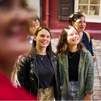 Mehrere Personen stehen auf einem gepflasterten Weg und blicken l&auml;chelnd in eine Richtung. Im Hintergrund sind bunte Geb&auml;ude zu sehen., &copy; Esslinger Stadtmarketing &amp; Tourismus GmbH
