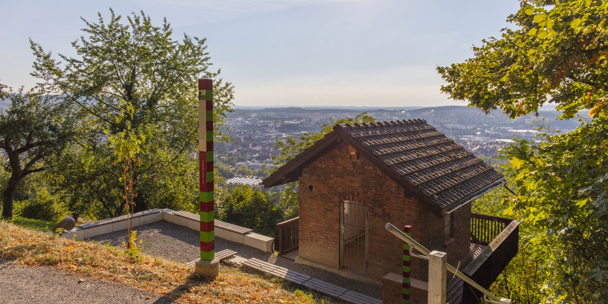 Kleines Backsteinhaus in den Metzinger Weinbergen, umgeben von Bäumen, mit Blick auf die Stadt im Hintergrund., © SMG Mende Kleines Backsteinhaus in den Metzinger Weinbergen, umgeben von Bäumen, mit Blick auf die Stadt im Hintergrund., © SMG Mende
