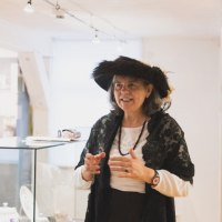 Eine Frau in historischer Kleidung steht in einem Museum neben einer Vitrine mit Porzellan. Sie tr&auml;gt einen schwarzen Hut und eine Spitzenjacke., &copy; Eigenbetrieb Tourismus und Citymanagement Schorndorf