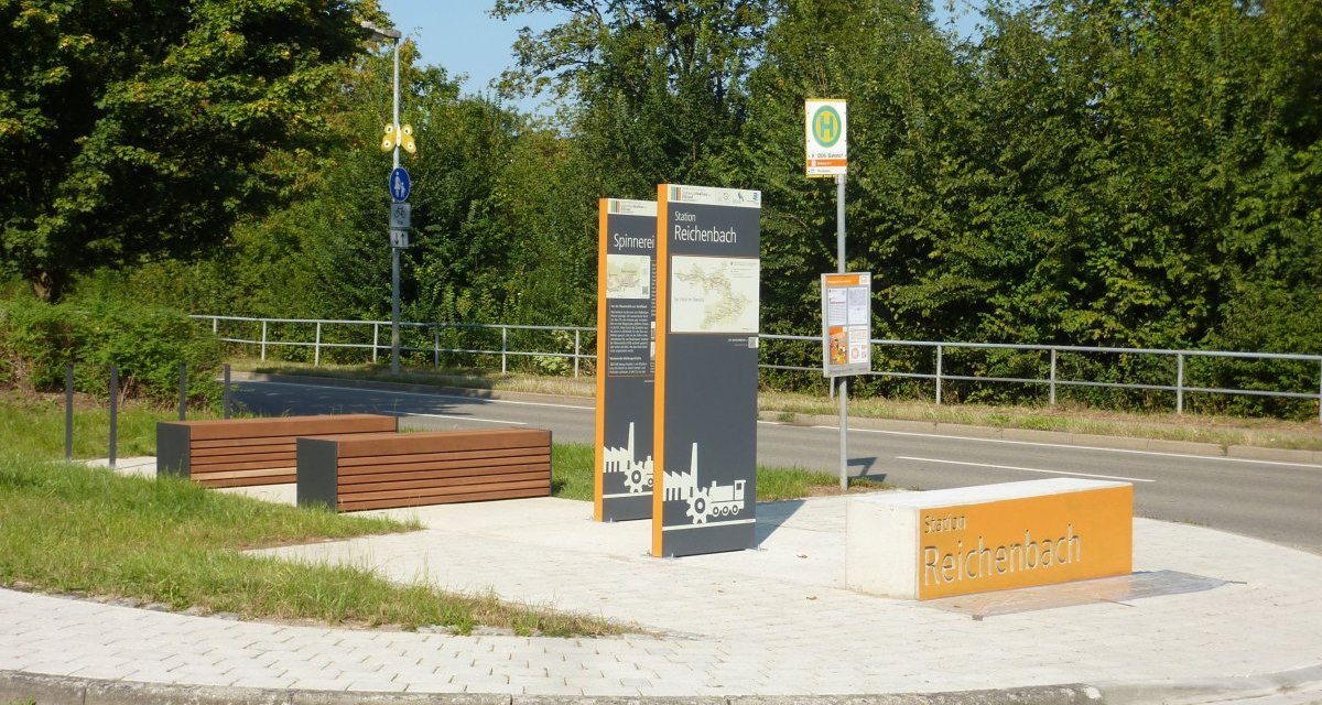 Station Reichenbach mit Infotafeln zur Industriekultur und Sitzbänken. Im Hintergrund eine Bushaltestelle und grüne Vegetation., © Verband Region Stuttgart Station Reichenbach mit Infotafeln zur Industriekultur und Sitzbänken. Im Hintergrund eine Bushaltestelle und grüne Vegetation., © Verband Region Stuttgart