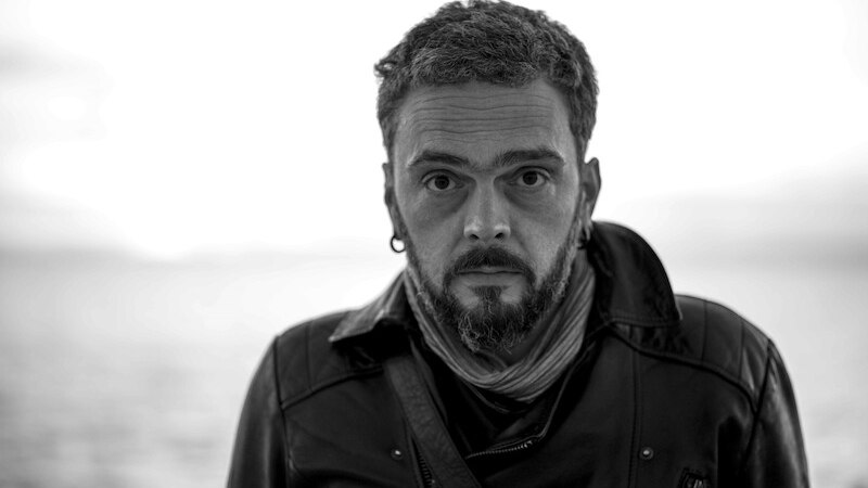 Schwarz-weiß Porträt eines Mannes mit Bart und Lederjacke, der direkt in die Kamera schaut. Der Hintergrund ist unscharf., © Kulturhaus Schwanen