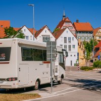 Wohnmobil auf einem Parkplatz in Bietigheim-Bissingen, umgeben von historischen Fachwerkhäusern und blauem Himmel., © SMG, Thomas Niedermüller Wohnmobil auf einem Parkplatz in Bietigheim-Bissingen, umgeben von historischen Fachwerkhäusern und blauem Himmel., © SMG, Thomas Niedermüller