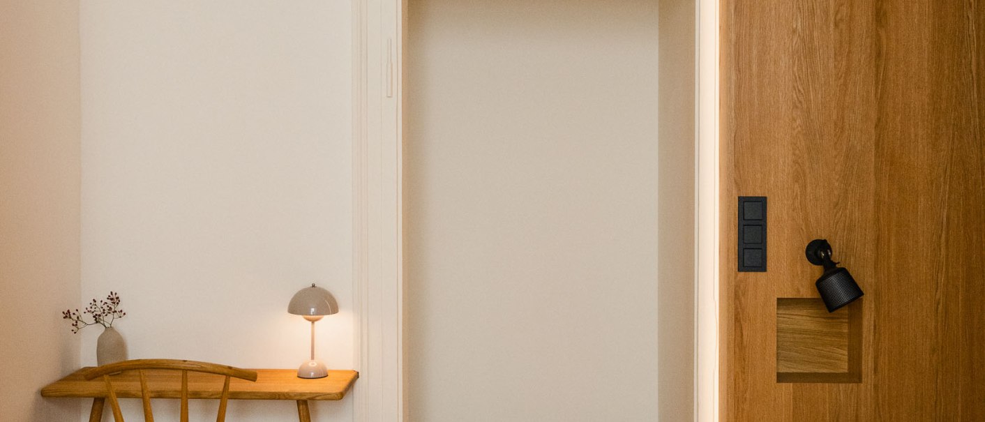 Minimalistisches Zimmer mit Holzboden, kleinem Tisch und Stuhl, Lampe, Bett mit Holzverkleidung. Schlichte, helle Einrichtung., © Peter Oliver Wolff / DAS EDITH