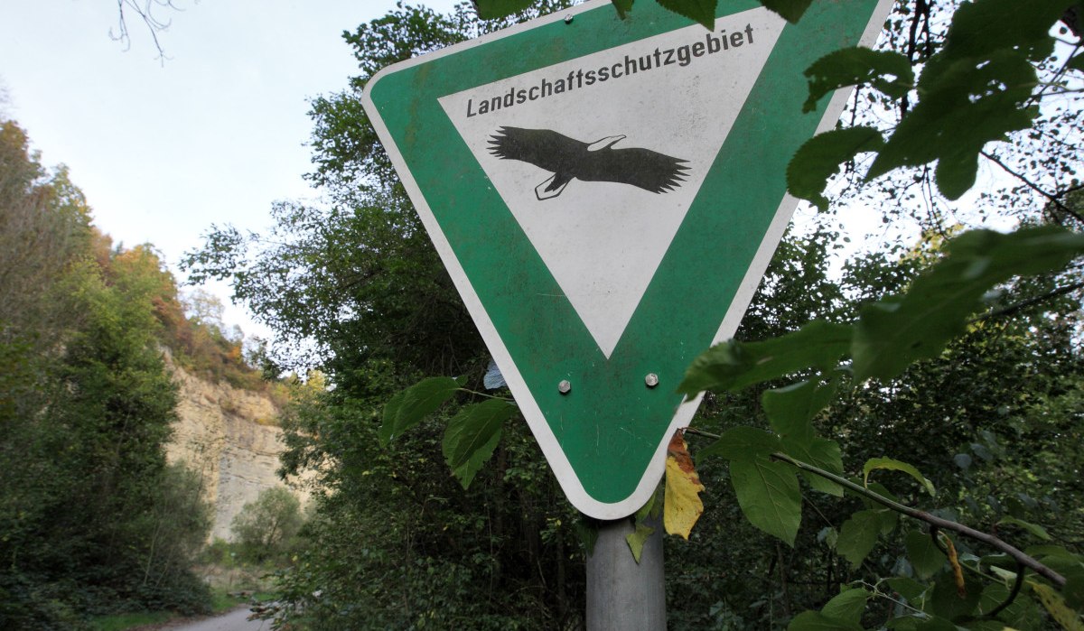 Schild 'Landschaftsschutzgebiet' mit Vogelmotiv, umgeben von Bäumen. Ein Weg führt durch die grüne Landschaft im Hintergrund., © Remstal Tourismus e.V.
