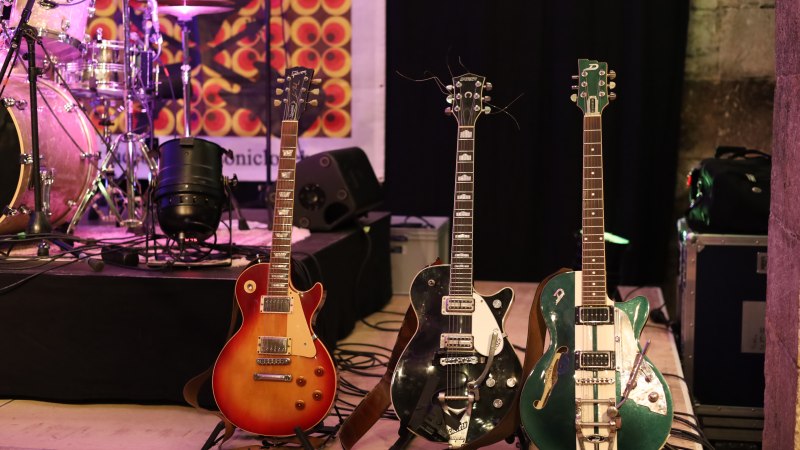 Drei E-Gitarren stehen auf einer B&uuml;hne neben einem Schlagzeug. Im Hintergrund ist ein buntes Banner zu sehen., &copy; Stadt N&uuml;rtingen