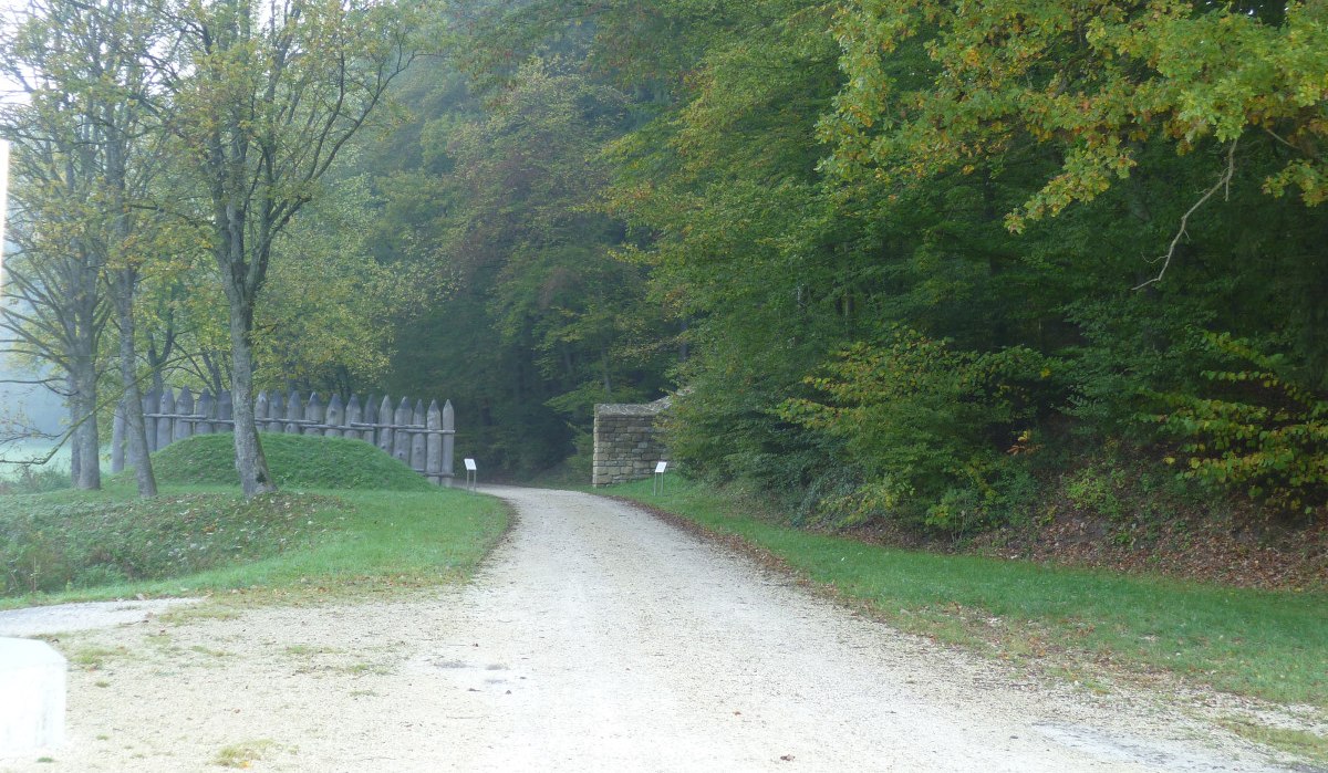 Ein Weg führt durch einen Wald, gesäumt von Bäumen. Links steht ein Holzzaun, rechts eine kleine Steinmauer. Herbstliche Farben dominieren., © Remstal Tourismus e.V. Ein Weg führt durch einen Wald, gesäumt von Bäumen. Links steht ein Holzzaun, rechts eine kleine Steinmauer. Herbstliche Farben dominieren., © Remstal Tourismus e.V.