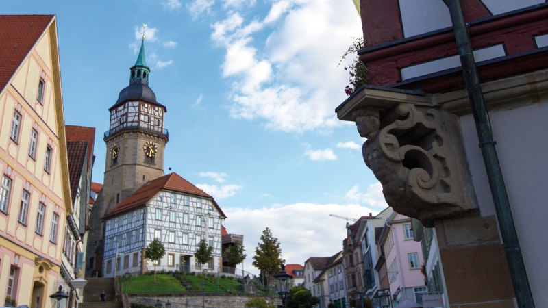 Der Backnanger Stadtturm mit seiner Uhr und Fachwerkh&auml;usern im Vordergrund. Der Himmel ist blau mit einigen Wolken., &copy; Stuttgart-Marketing GmbH, Achim Mende