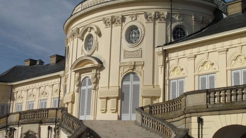 Schloss Solitude mit seiner eleganten, geschwungenen Treppe und kunstvollen Fassadendetails vor einem klaren blauen Himmel., © RadL Leonberg Schloss Solitude mit seiner eleganten, geschwungenen Treppe und kunstvollen Fassadendetails vor einem klaren blauen Himmel., © RadL Leonberg