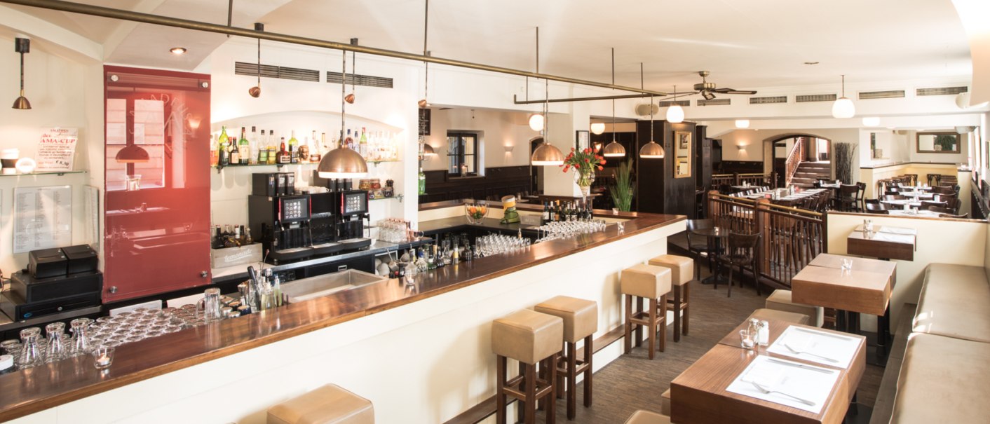 Stilvolles Restaurant mit Bar, Holzmöbeln und gedeckten Tischen. Helle Beleuchtung und gemütliche Atmosphäre., © Amadeus, Stuttgart