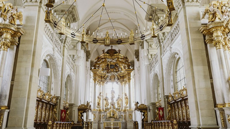 Prächtiger Kircheninnenraum der Großcomburg in Schwäbisch Hall mit reich verziertem Altar, goldenen Statuen und kunstvollen Verzierungen., © Nico Kurth