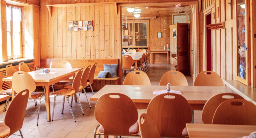 Holzvertäfelter Raum mit mehreren Tischen und Stühlen, Fenster links, gemütliche Atmosphäre., © DJH Baden-Württemberg e.V.